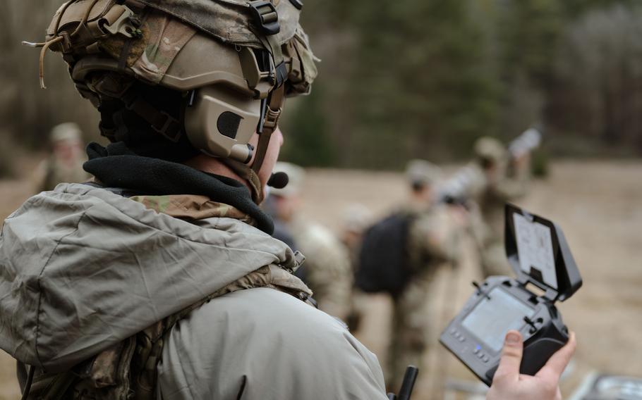 A soldier holds flight controller as he pilots a drone.