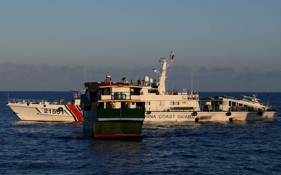A China Coast Guard vessel, rear, sailing near the Philippines military chartered Unaizah May 4, front, during its supply mission to Second Thomas Shoal in the disputed South China Sea on March 5, 2024.