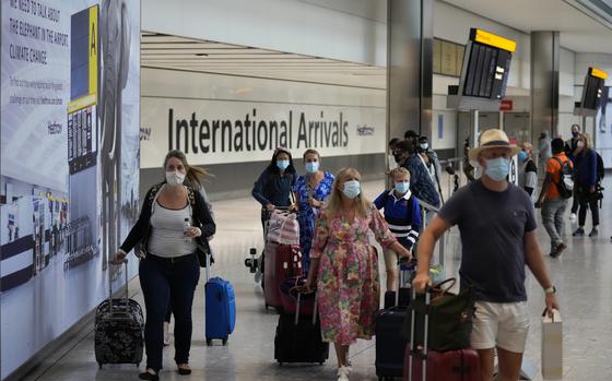 FILE - Passengers arrive at Terminal 5 of Heathrow Airport in London, Aug. 2, 2021. British Prime Minister Boris Johnson said Monday Jan. 24, 2022, his government will remove coronavirus testing requirements for vaccinated people arriving in England, news hailed by the travel industry as a big step back to normality. (AP Photo/Matt Dunham, File)