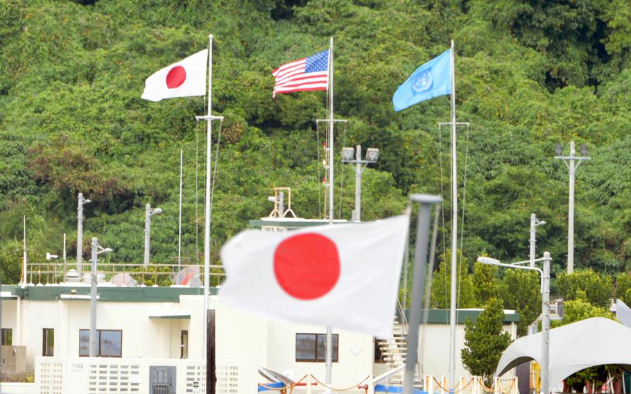 Japanese, American and United Nations flags flap in the breeze at Naval Base White Beach, Okinawa, April 14, 2023. 