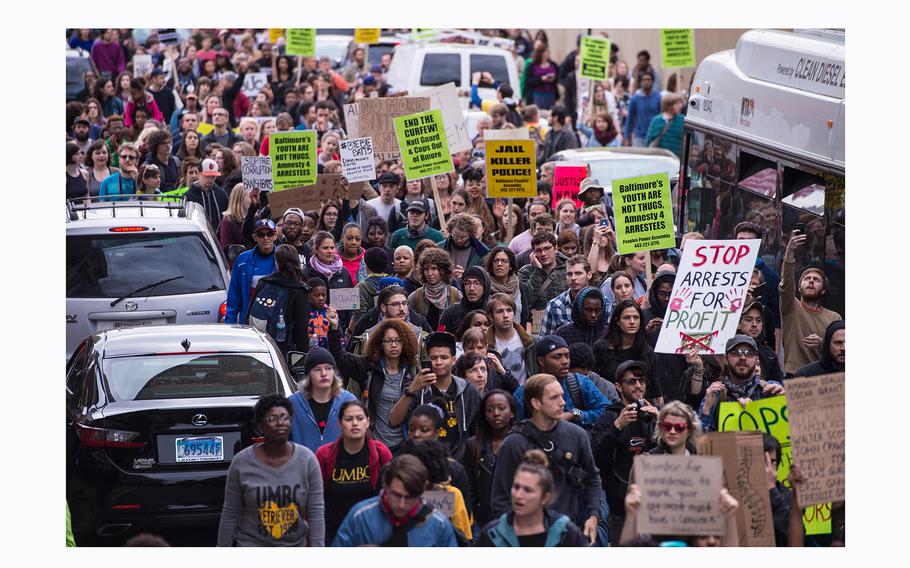 Protesters march by the Baltimore Central Booking and Intake Center on May 1, 2015, after it was announced that criminal charges would be brought against all 6 officers involved in the Freddie Gray case