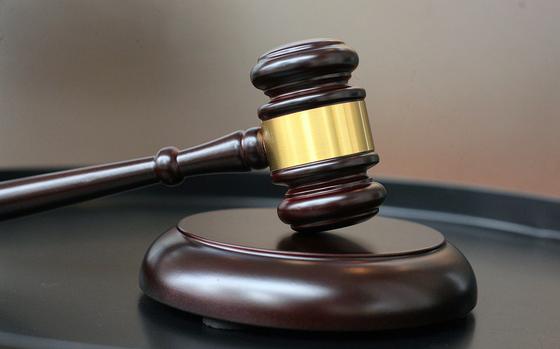 A judge’s gavel rests on a small wooden platform.