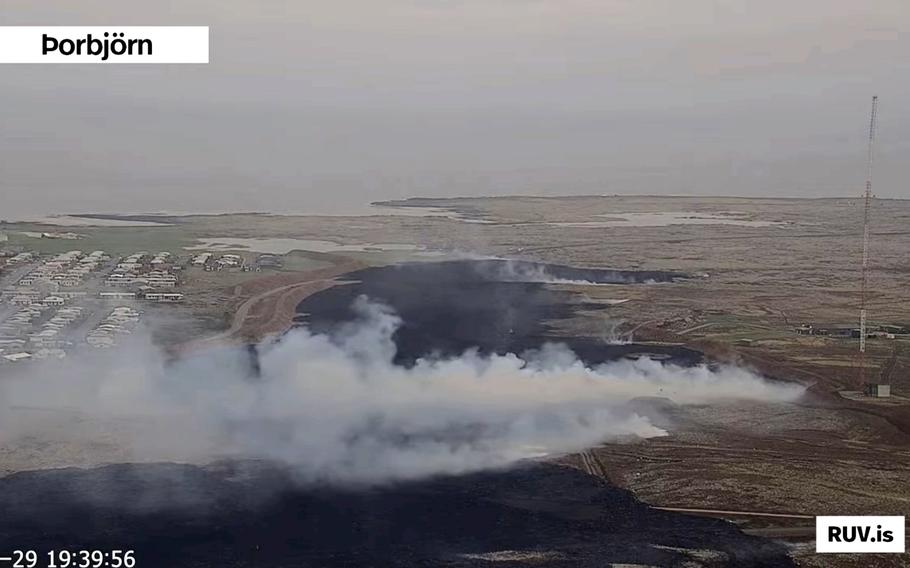 A screenshot of live footage from Iceland’s national broadcaster RÚV on May 29, 2024, shows smoke billowing from the ground near a communications mast used by the U.S. Navy, at right.