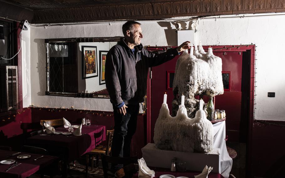 A man lights a Prohibition-era candle at John’s of 12th Street in New York. 