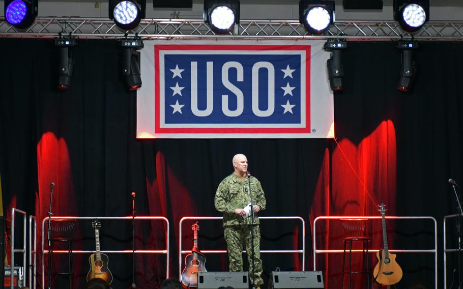 A Navy officer speaks to people at a USO show.