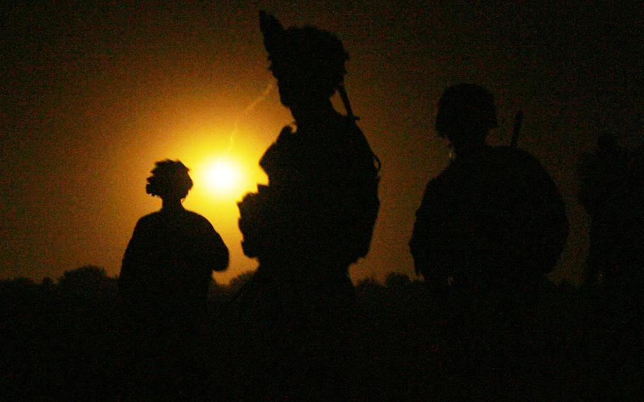 Soldiers with Company C, 1st Battalion, 32 Infantry Regiment, 3rd Brigade Combat Team, 10th Mountain Division are lit up by luminary rounds as they wait for their helicopters during Operation Steel Lion III.