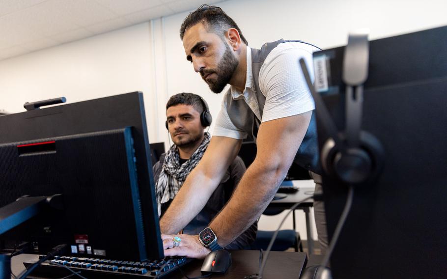 Mirwais Jalali, a recruiter for aviation contractor Unifi, helps candidate Nametulah Sultani begin a computer training program at Unifi offices in Hapeville on Friday, April 19, 2024.