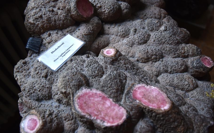 Sections of rhodochrosite, a light pink to bright red manganese carbonate mineral, can be seen exposed in a rock formation from Argentina, on display at the German Museum of Minerals in Idar-Oberstein. Rhodochrosite is Argentina’s national gemstone and is often used in jewelry.