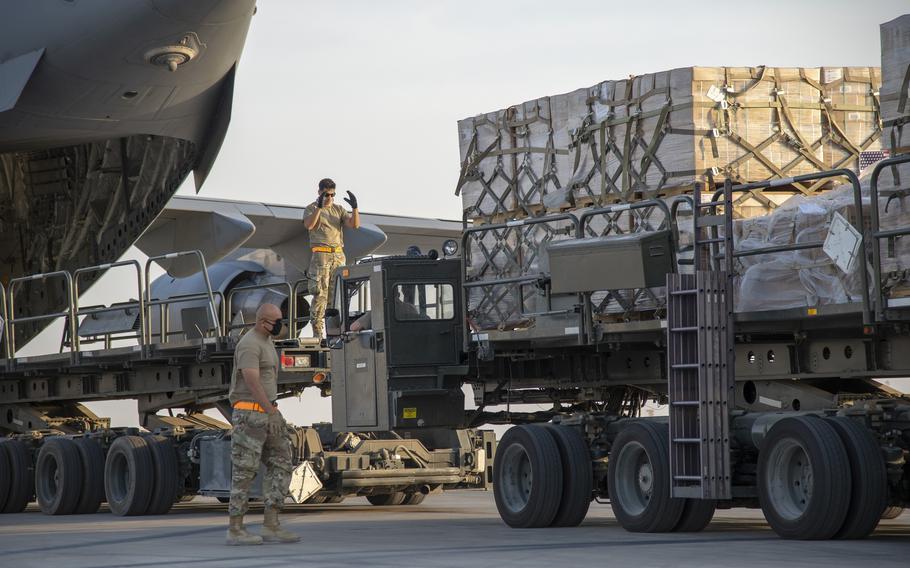 US Airmen load humanitarian aid into a plane.