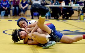 Ramstein's Genesis Esparza puts Stuttgart's Preston Schneider into a headlock during a 120-pound match at the Warrior Wraggle on Jan. 13, 2024, at Wiesbaden High School in Wiesbaden, Germany.