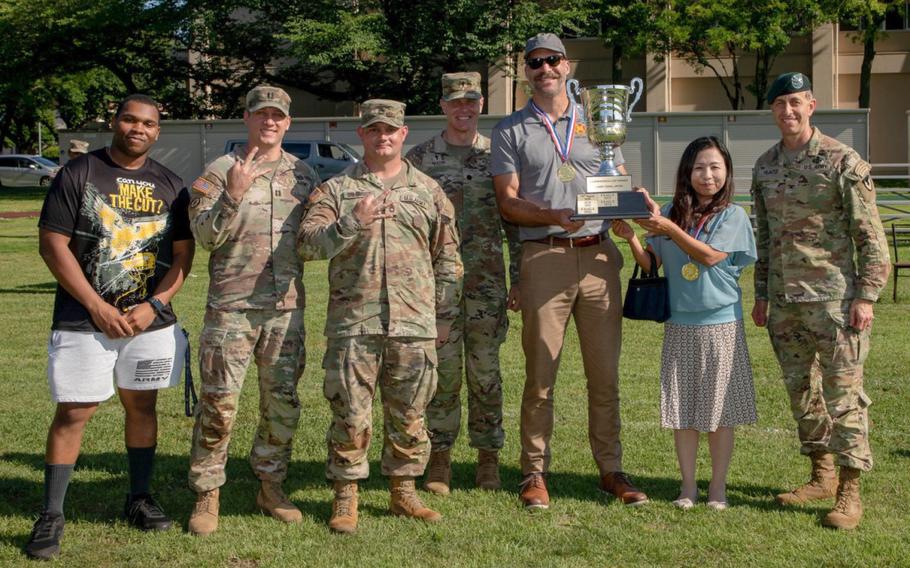 Col. Marcus Hunter, right, commander of U.S. Army Garrison Japan, and other garrison team members accept the Commander’s Cup trophy during an awards ceremony at Camp Zama, Japan, June 12, 2024. The garrison team completed a three-peat of the Commander’s Cup program for its consistent performance in 25 different fitness and sports events.