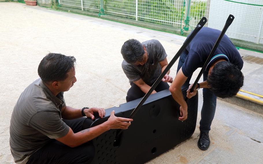 Marine Gunnery Sgt. Mario Sanchez Jr., left, helps assemble a basketball goal he donated to the Urawa Women's Shelter in Urasoe city, Okinawa, Aug. 28, 2024.