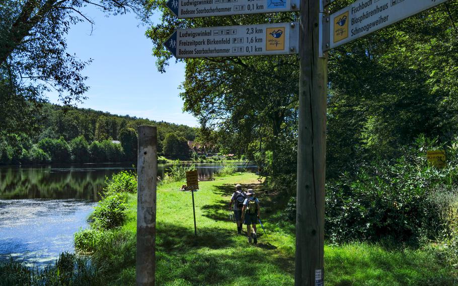 A couple of hikers make their way toward the Saarbacherhammer swimming area near Ludwigswinkel, Germany, on Aug. 11, 2024. The lake is a refreshing end to a day of exploring the area, which borders France.