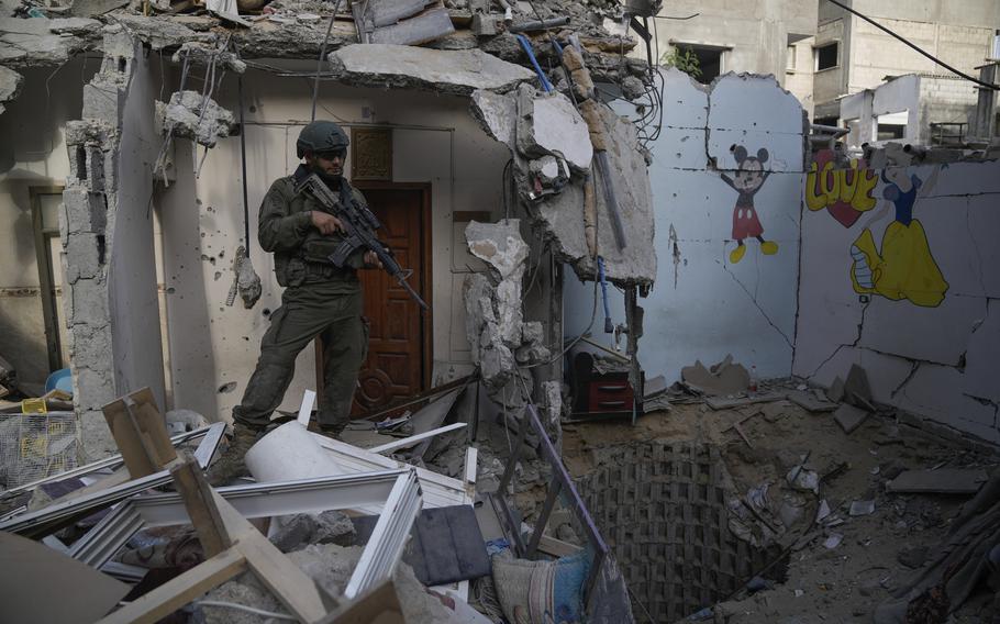 An Israeli soldier stands at the entrance to a tunnel where hostages were killed