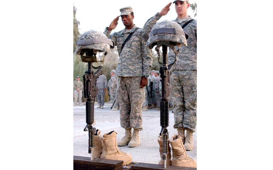 U.S. soldiers salute Monday during a memorial service honoring Staff Sgt. Alex Jimenez and Spc. Byron Fouty in Baghdad.