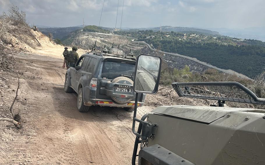 Two Israel Defense Force vehicles stop on a road near the Lebanese border.