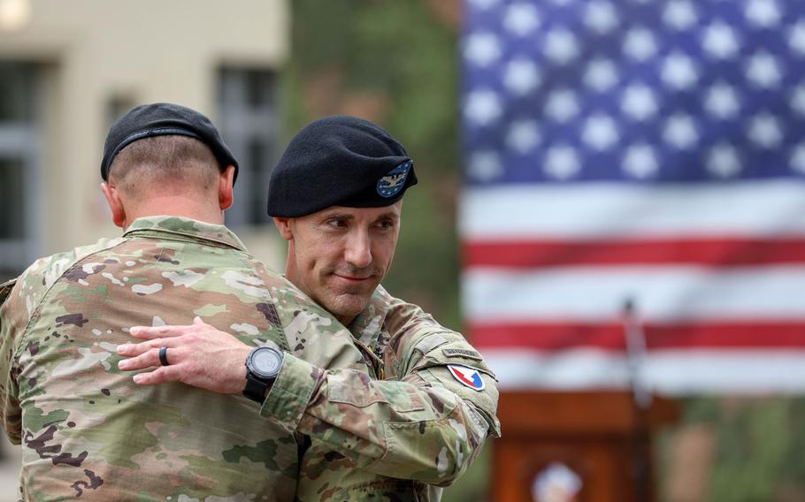 Col. Christopher Church, right, outgoing commander of U.S. Army Garrison Poland, embraces incoming commander Col. Jesse Chase during the garrison’s change of command ceremony in Poznan, Poland, on June 28, 2024.