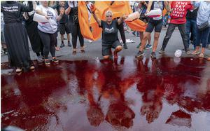 Demonstrators pour fake blood on the asphalt as they protest Israeli Prime Minister Benjamin Netanyahu visit to the White House during a rally in Washington on July 25, 2024.