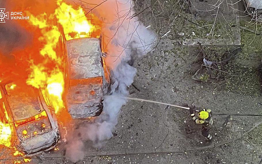 Ukrainian emergency services work to extinguish a fire after a rocket attack.