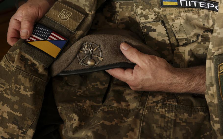 John Peters holds his son’s uniform.