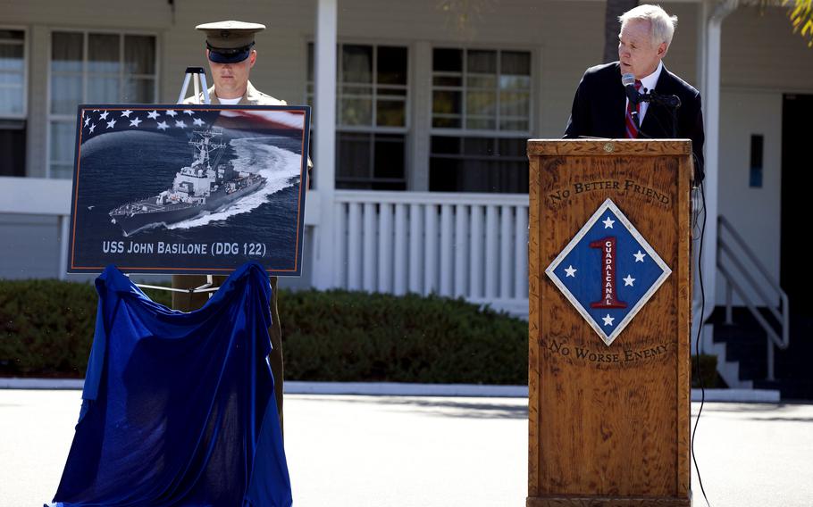 Then-Secretary of the Navy Ray Mabus , right, has a graphic of the USS John Basilone unveiled during the naming ceremony for the ship at Camp Pendleton, Calif., in 2016. 