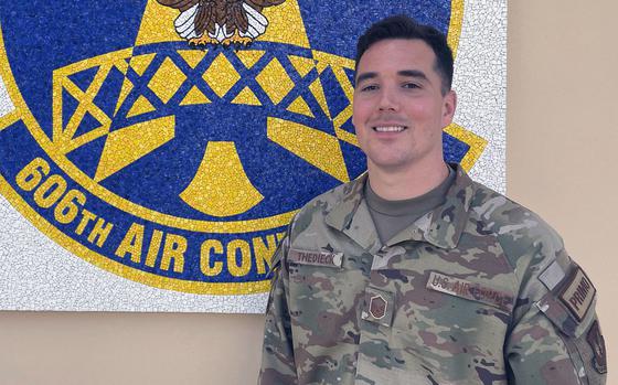 Master Sergeant Darren Thedieck poses for a photo in front of his unit crest at Aviano Air Base, Italy, on June 3, 2024. Thedieck has amassed a net worth of over $600,000, and he runs a Facebook group to offer investing insights to fellow service members.