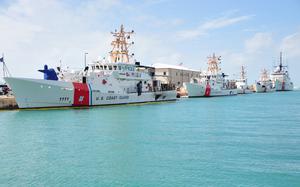 A coast guard cutter is moored to a pier.