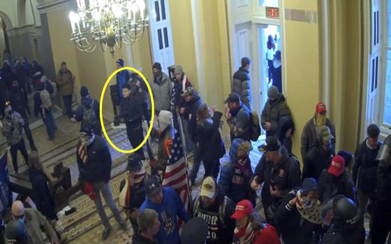 This image from video from the Justice Department in the statement of facts supporting an arrest warrant, and annotated by the source, shows Kevin Alstrup, circled in yellow, a U.S. State Department diplomatic security officer, entering the U.S. Capitol on Jan. 6, 2021, in Washington. (Justice Department via AP)