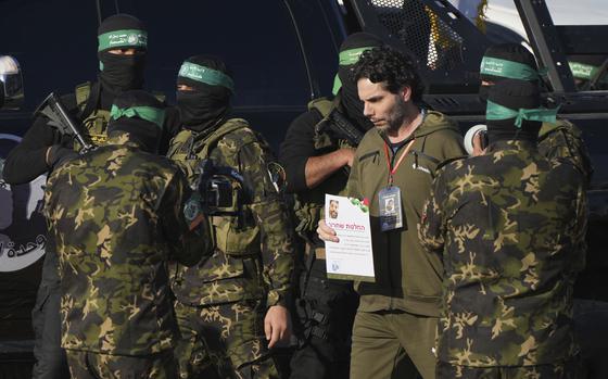 An Israeli hostage walks next to Hamas fighters while being handed over to the Red Cross.