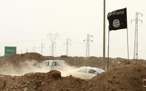 FILE - Islamic State militants pass a checkpoint bearing the group's trademark black flag in the village of Maryam Begg in Kirkuk, 180 miles north of Baghdad, Iraq, Sept. 29, 2014. 