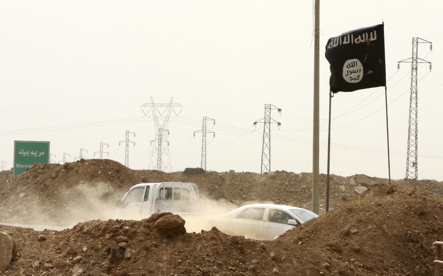 The Islamic State group’s trademark black flag is seen in the village of Maryam Begg in Kirkuk, 180 miles north of Baghdad, Sept. 29, 2014. 