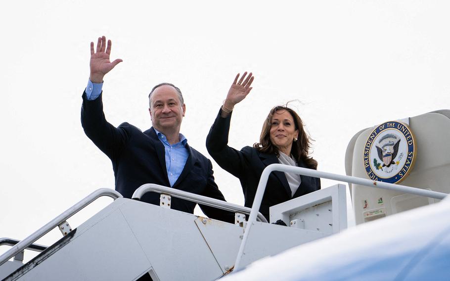 Vice President and Democratic presidential candidate Kamala Harris and her husband Doug Emhoff wave as they board Air Force 2 at Delaware Air National Guard base in New Castle, Delaware, on July 22, 2024. 