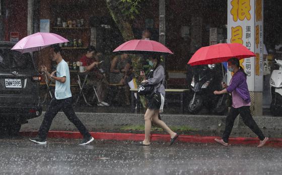 People walk through the rain in Taipei, Taiwan, on July 24, 2024, as Typhoon Gaemi approaches.