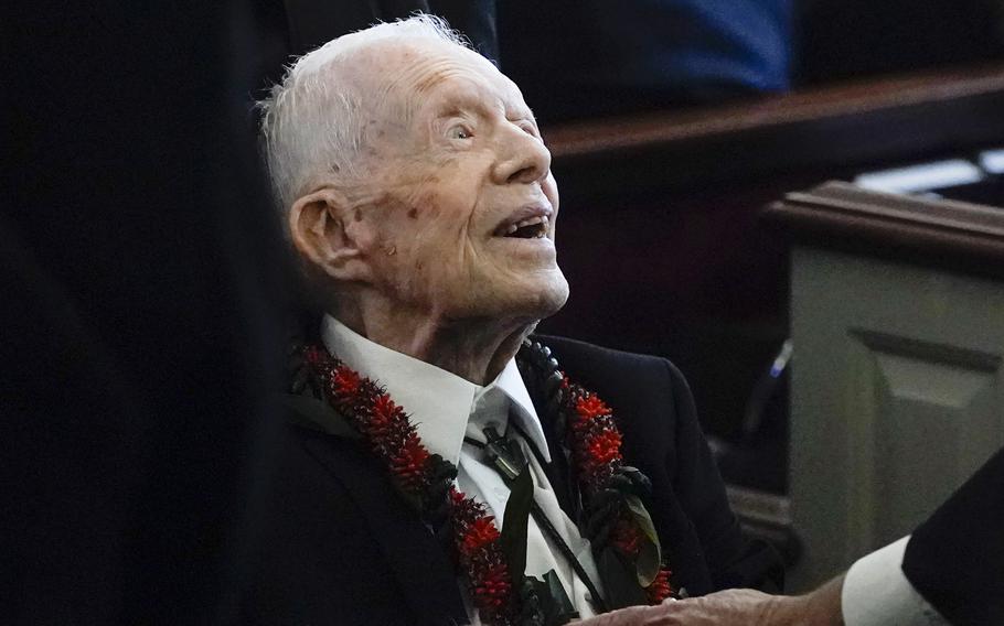 Jimmy Carter sits in a wheelchair at a church during the funeral service for his wife.