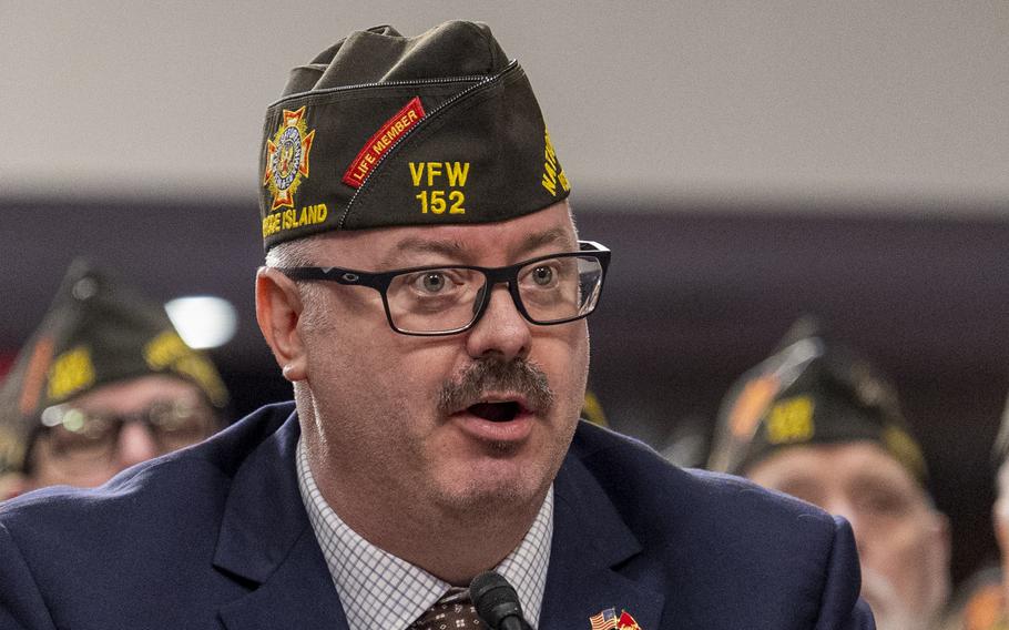 A man wearing glasses and a veterans hat speaks.