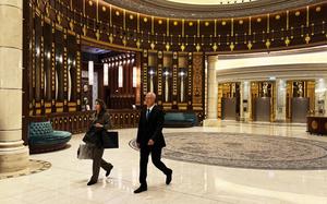 A man and a woman walk across the Ritz Carlton hotel.