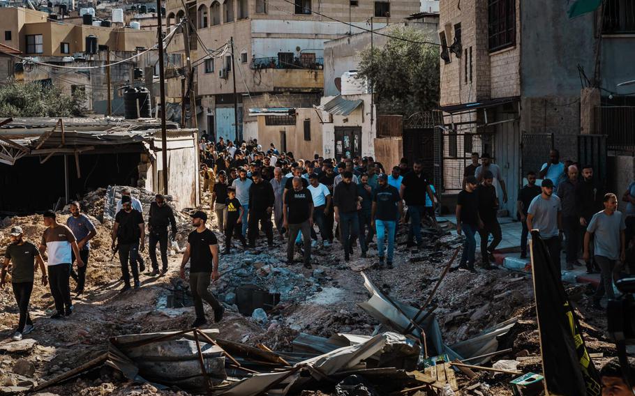 Mourners attend a mass funeral for 14 Palestinians killed after Israeli forces raided the refugee camp in Jenin, Occupied West Bank, Friday, Nov. 10, 2023.