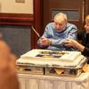 World War II veteran Norman Jay Green prepares to cut a large cake during his 100th birthday celebration at the New Sanno Hotel in Tokyo, Nov. 22, 2024. The cake features the insignia and motto of the 326th Glider Infantry Regiment: “Aspera Juvant,” Latin for “Difficult Delight.” 