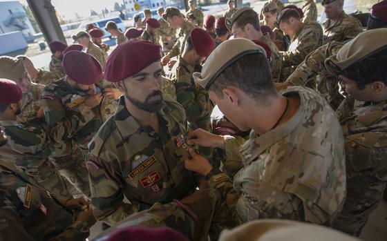 A Green Beret pins a jump wing on to the chest of a member of India’s special forces. 