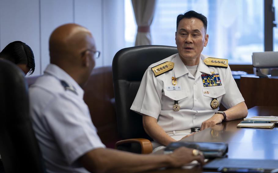 A U.S. Air Force general meets with a South Korean admiral. Both are seated and in uniform.