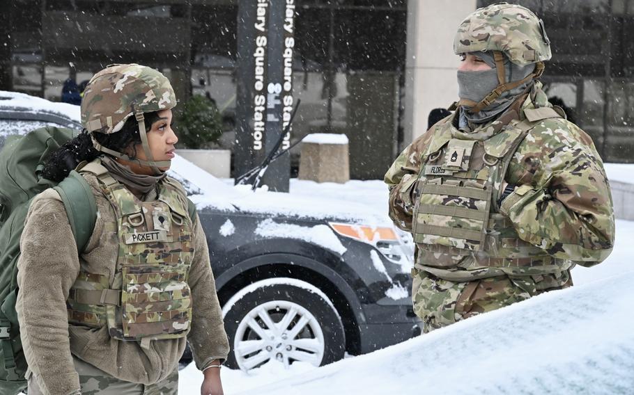 National Guard soldiers talk in the snow