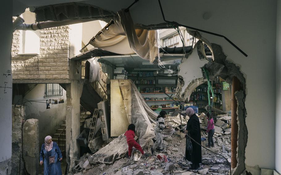 Civilians walk in the heavily damaged neighbourhood of a-Damaj in Jenin refugee camp on Nov. 29, 2023. 