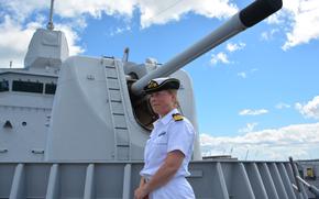 Cmdr. Yvonne van Beusekom, commander of the Royal Netherland Navy frigate HNLMS Tromp, stands beside a 127-mm cannon on the ship’s bow while talking with reporters on June 28, 2024, at Joint Base Pearl Harbor-Hickam, Hawaii.