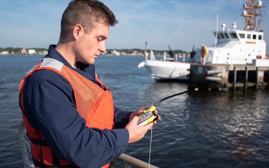 A Coast Guardsman demonstrates how to use a personal locator beacon in Mayport, Fla., Setp. 30, 2020.