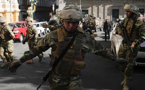 A soldier gestures for journalists to leave Plaza Murillo as soldiers gather near the presidential palace in Plaza Murillo in La Paz, Bolivia, Wednesday, June 26, 2024. (AP Photo/Juan Karita)