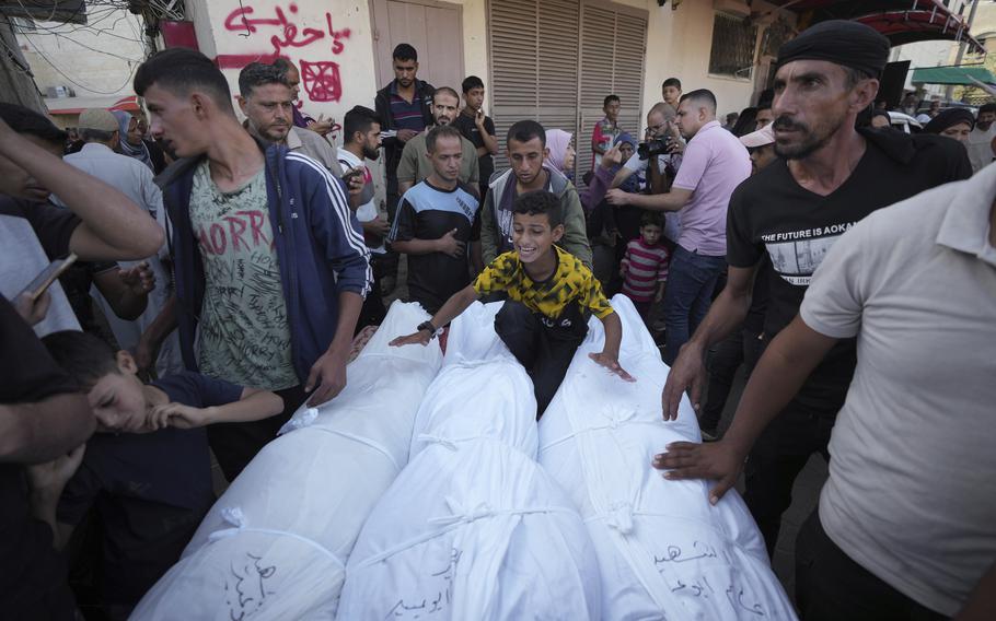 Mourners gather around the bodies of three Palestinians outside the hospital morgue in Deir al-Balah on Wednesday, Oct. 9, 2024. 