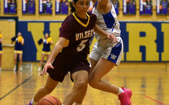 Vilseck's Jayslin Santellano drives against Wiesbaden's Katie Shea during a Jan. 17, 2025, game at Wiesbaden High School in Wiesbaden, Germany.