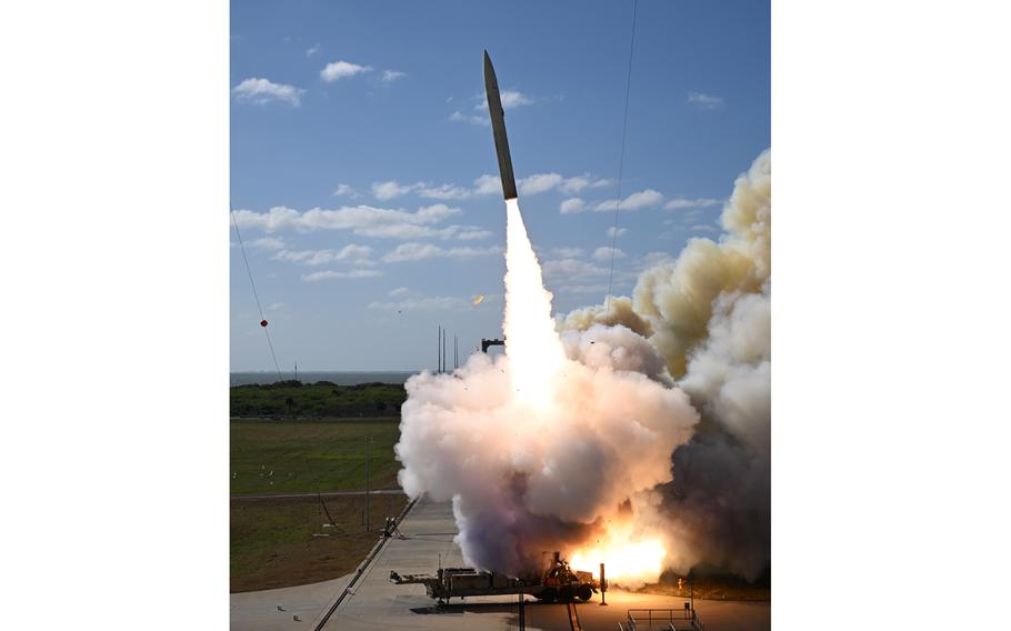 A missile/rocket is seen blasting off from a launch pad.