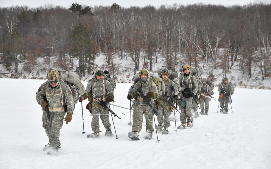 A group of airmen march together in the snow