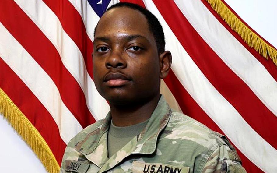 Army Sgt. Quandarius Davon Stanley poses in front of a U.S. flag.